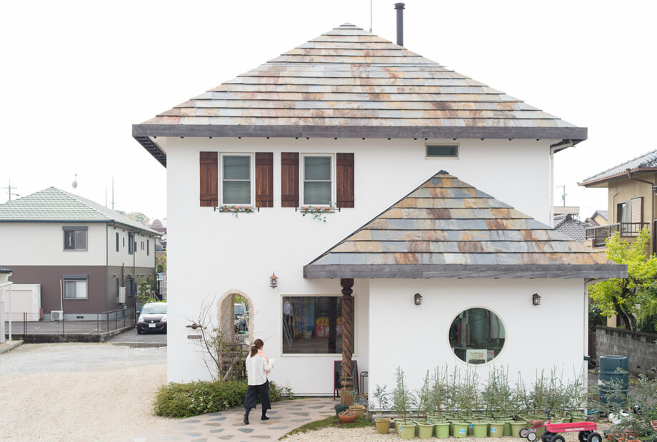 漆喰壁と石屋根と丸窓が印象的な外観